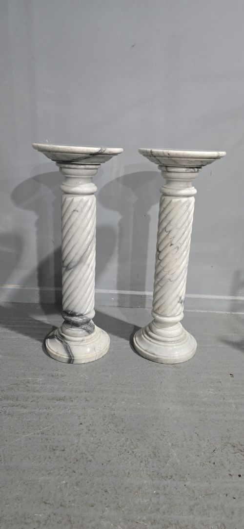 fig 1. A pair of carved white and grey variegated marble pedestals with spiral shafts, circular capitals, and stepped moulded bases.