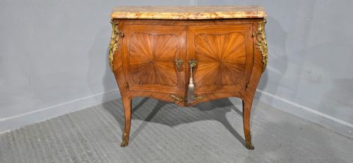 fig 1. A French Louis XV style two-door cabinet featuring sunburst parquetry woodwork, a variegated marble top, cabriole legs, and ornate gilt bronze mounts.