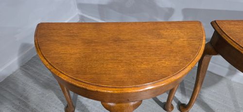 fig 1. A pair of semi-circular oak console tables with smooth tops and slender cabriole legs terminating in pad feet.