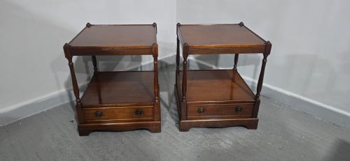 fig 1. A pair of dark mahogany two-tier lamp tables with turned corner supports and single base drawers featuring brass ring handles.