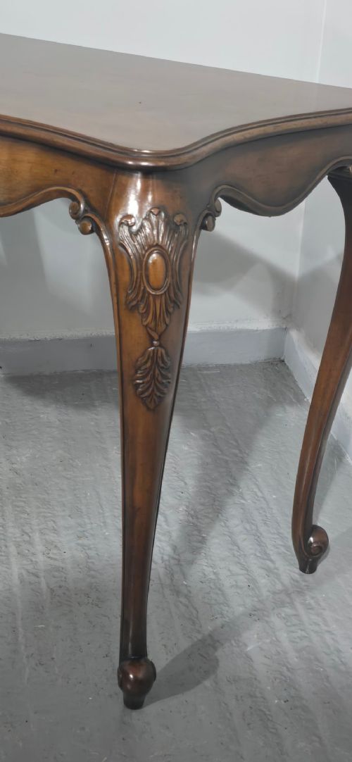 A dark mahogany console table featuring a shaped serpentine top, a central shell carving on the apron, and four cabriole legs. View VI