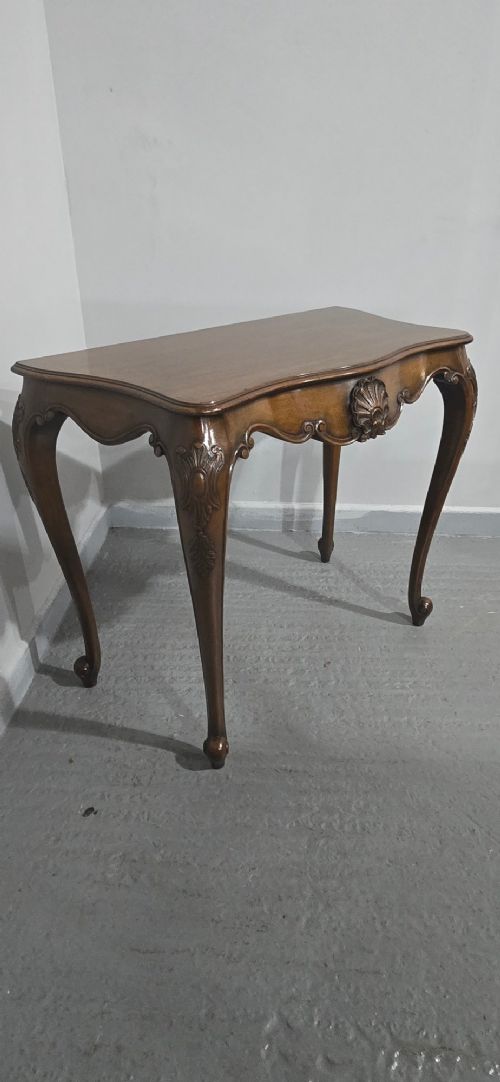 A dark mahogany console table featuring a shaped serpentine top, a central shell carving on the apron, and four cabriole legs. View XII
