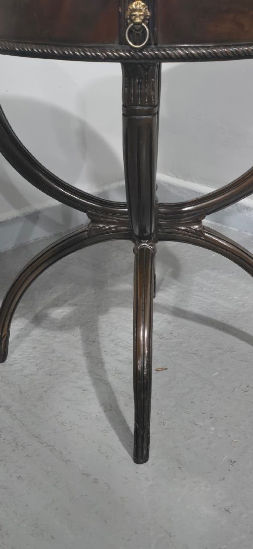 A circular mahogany occasional centre table with a segmented veneered top, brass lion mask handle, and curved reeded legs. View IV