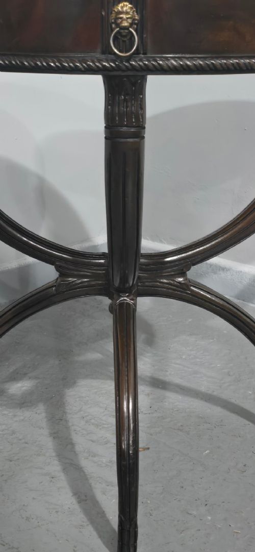 A circular mahogany occasional centre table with a segmented veneered top, brass lion mask handle, and curved reeded legs. View V