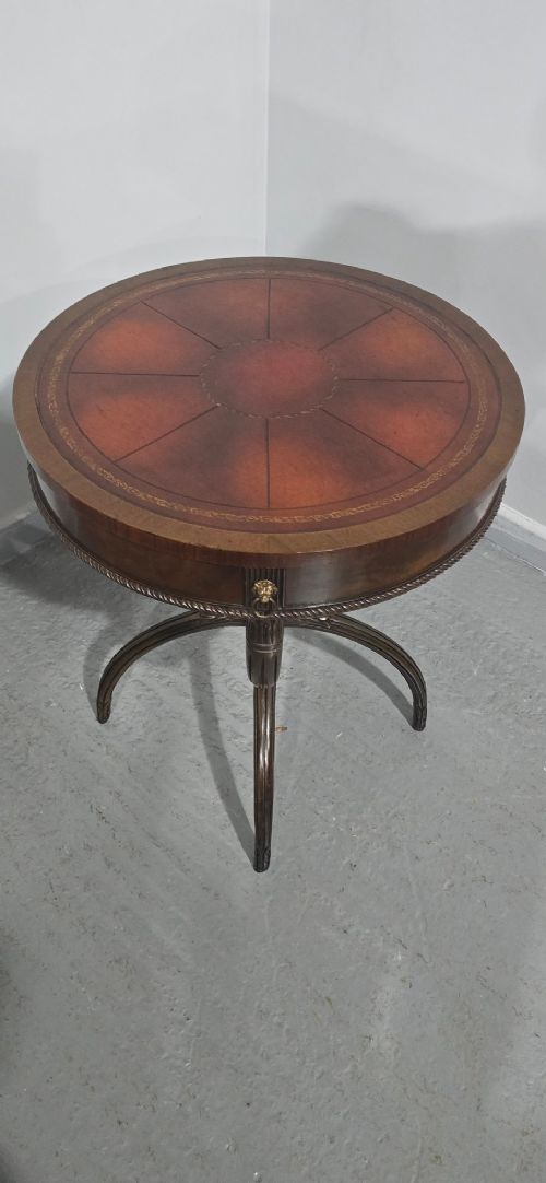 A circular mahogany occasional centre table with a segmented veneered top, brass lion mask handle, and curved reeded legs. View XI