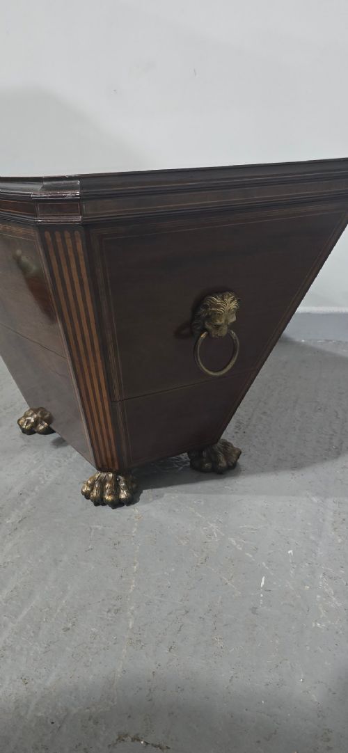 A tapered sarcophagus-shaped dark mahogany wine cooler featuring satinwood line inlay, brass lion paw feet, and a central keyhole with a green tassel. View III