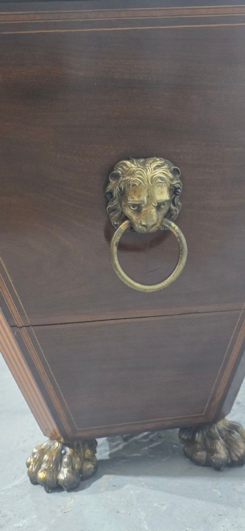 A tapered sarcophagus-shaped dark mahogany wine cooler featuring satinwood line inlay, brass lion paw feet, and a central keyhole with a green tassel. View IV