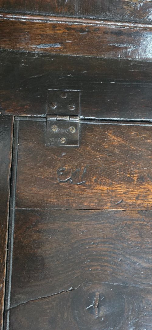 A dark carved oak monks bench featuring relief-carved panel work on the backrest and base, complete with curved armrests and a hinged storage seat. View VI