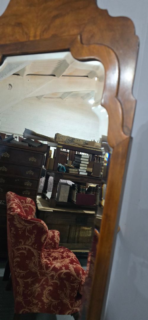 A standing Queen Anne style burr walnut cheval mirror featuring a shaped crest, tilting glass plate, finial-topped uprights, and cabriole legs. View VII