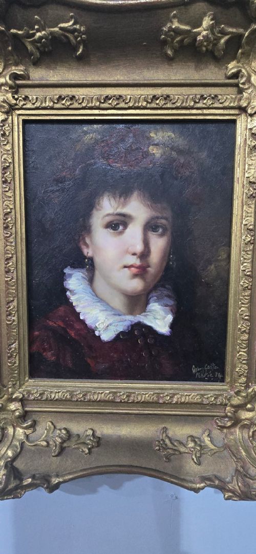 An oil painting on board depicting a young woman with dark hair and a ruffled white collar, displayed within a heavily carved gold Rococo style frame. View III