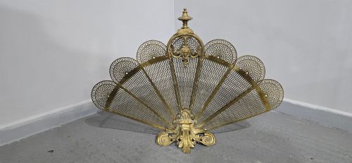 fig 1. An ornate Victorian brass peacock fire screen featuring pierced filigree fan panels, a finial crest, and a cast scrollwork base.