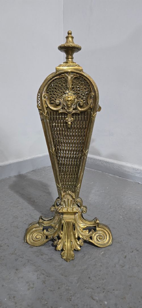 An ornate Victorian brass peacock fire screen featuring pierced filigree fan panels, a finial crest, and a cast scrollwork base. View X
