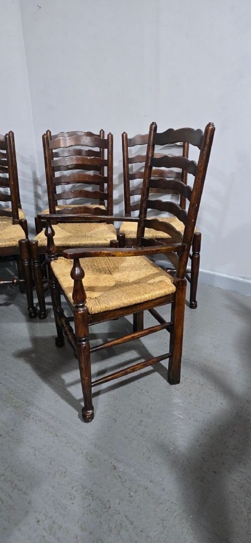 A set of eight dark oak ladder back dining chairs featuring woven rush seats, curved back rungs, and turned front legs with stretchers. View VIII