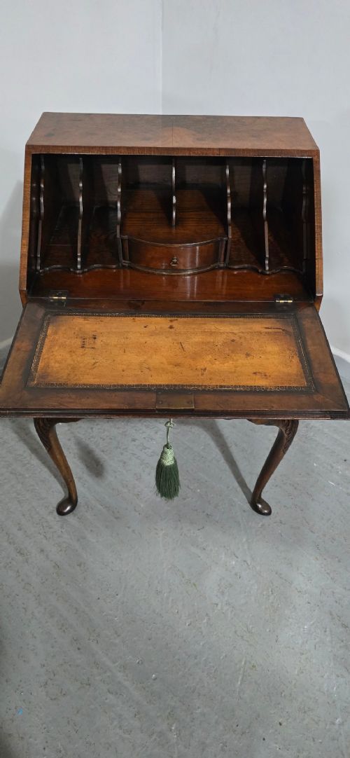 A Queen Anne style burr walnut writing bureau featuring a sloped front lid, shaped drawers with brass drop handles, and tall cabriole legs. View IX
