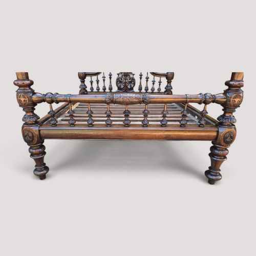 fig 1. A dark wood four-poster bed frame featuring carved spiral posts, turned spindles, and an arched cresting headboard.