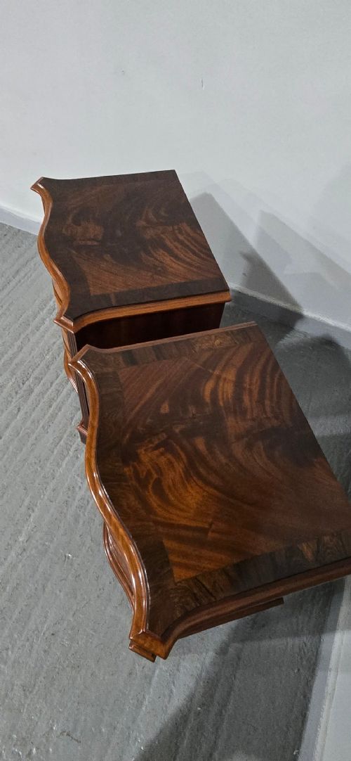 A matching pair of serpentine-fronted mahogany bedside chests, each featuring four drawers with inlay crossbanding and circular brass ring handles. View VIII