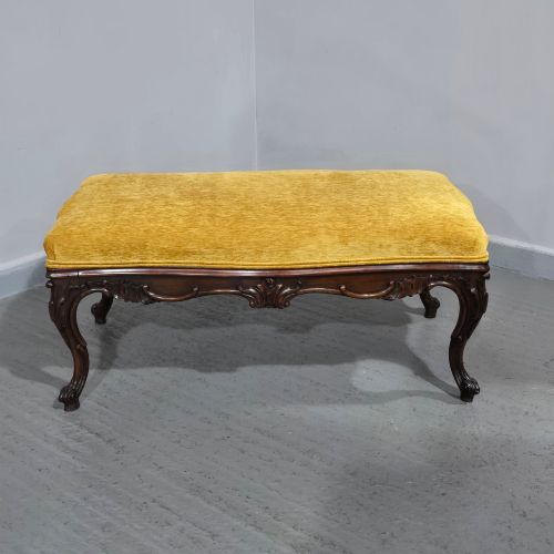 fig 1. A rectangular Regency period stool featuring a mustard yellow fabric top resting on a dark carved rosewood frame with cabriole legs.