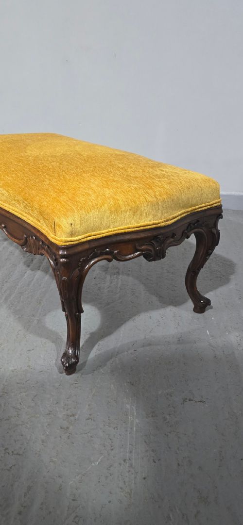 A rectangular Regency period stool featuring a mustard yellow fabric top resting on a dark carved rosewood frame with cabriole legs. View VIII