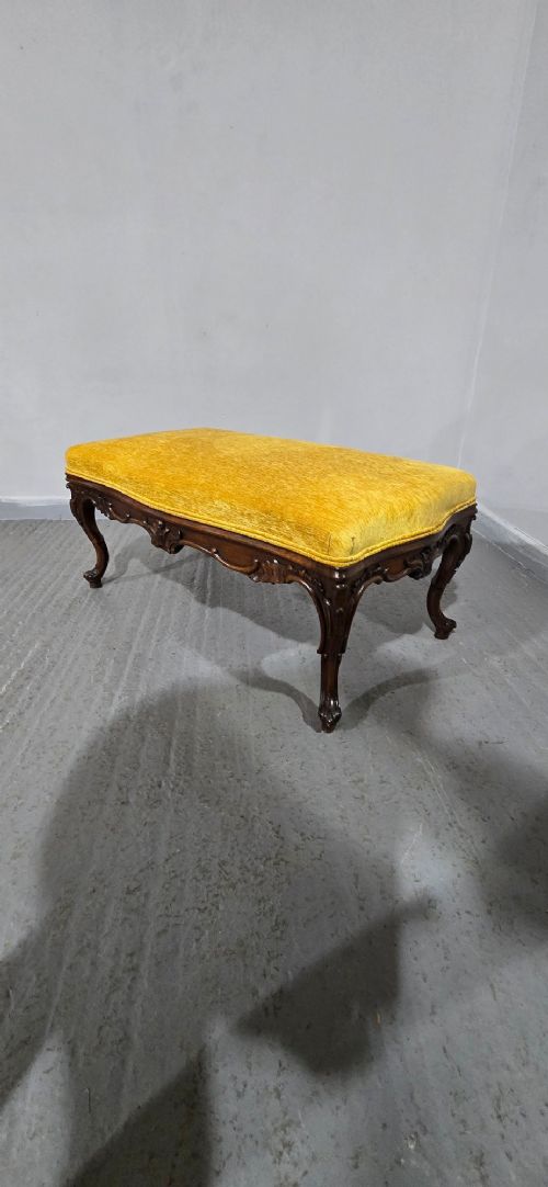 A rectangular Regency period stool featuring a mustard yellow fabric top resting on a dark carved rosewood frame with cabriole legs. View IX