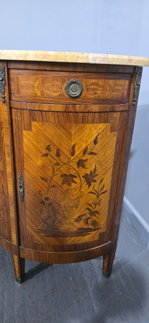 A French Louis XVI style demi-lune cabinet featuring intricate floral marquetry inlay, gilt-bronze mounts, and a contoured marble top. View VI