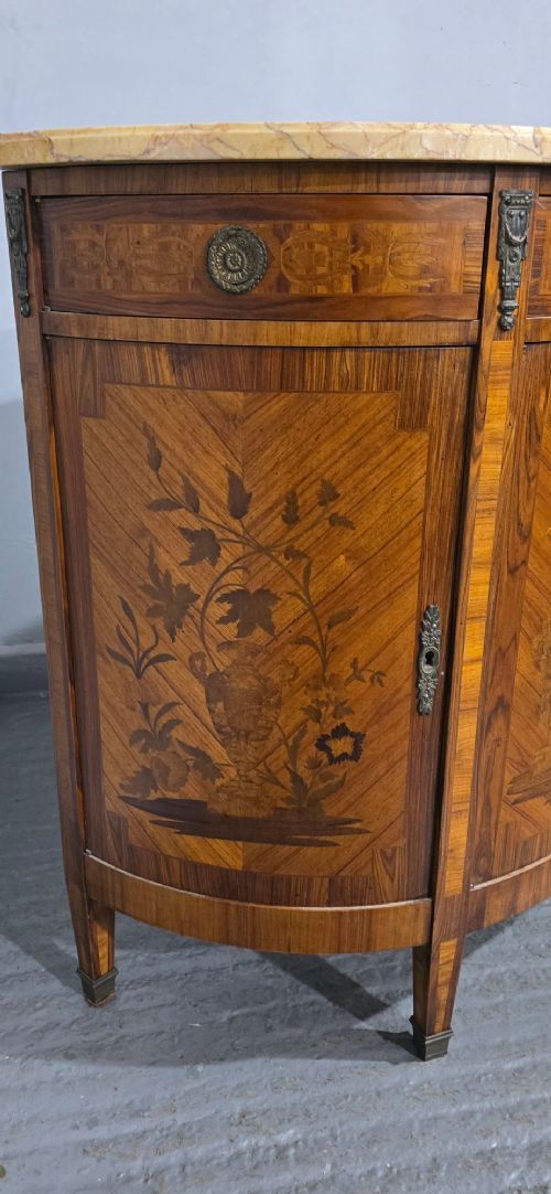 A French Louis XVI style demi-lune cabinet featuring intricate floral marquetry inlay, gilt-bronze mounts, and a contoured marble top. View VII