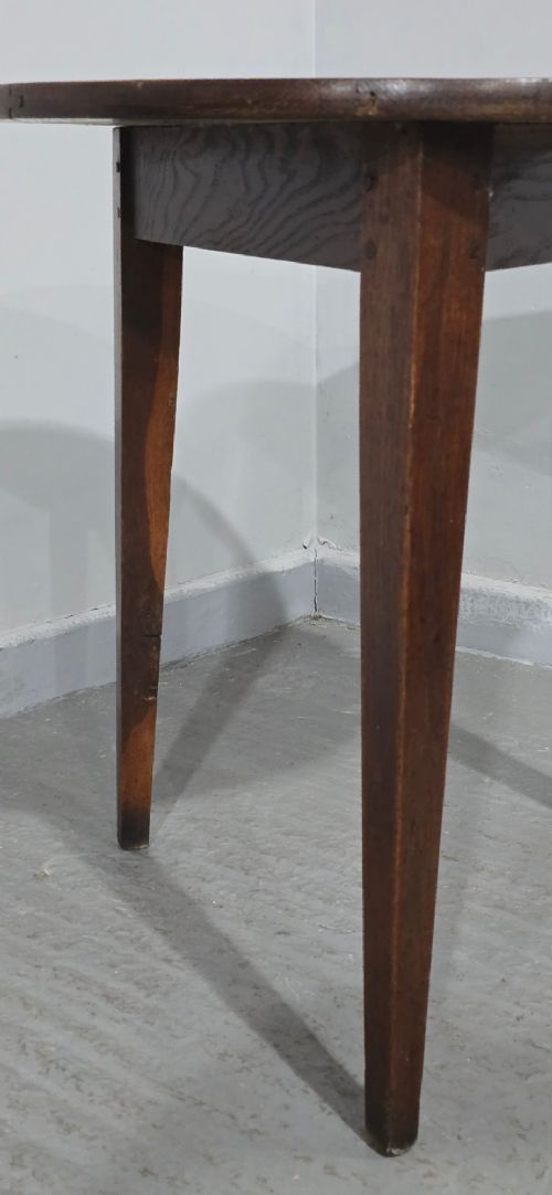 A dark brown Georgian oak cricket table featuring a circular planked top supported by three splayed tapered legs. View VIII