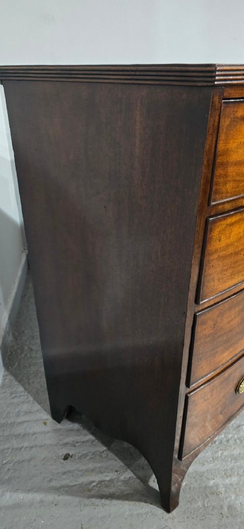 A Georgian mahogany bowfront chest of drawers featuring four graduated drawers with oval brass handles and splayed feet. View VIII