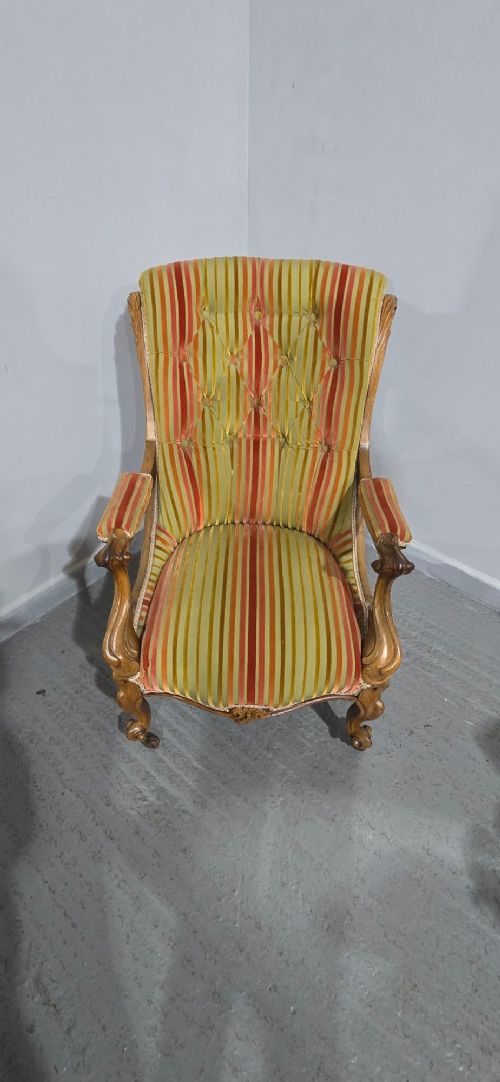 A Regency style rosewood library armchair with button-tufted striped upholstery, carved scroll arms, cabriole legs, and brass castors. View IV