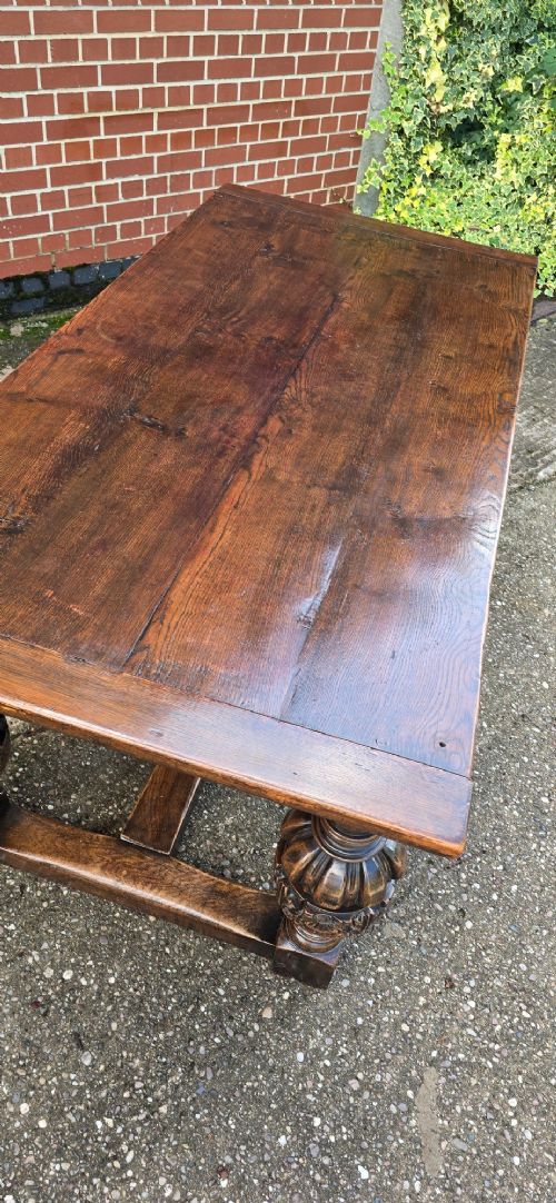 A heavy dark oak refectory dining table featuring carved cup-and-cover bulbous legs and a low stretcher base. View VIII