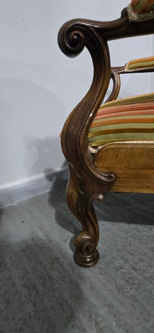 A Regency rosewood armchair featuring a button-tufted backrest, scrolled arms, carved legs, and striped green and red upholstery. View IX