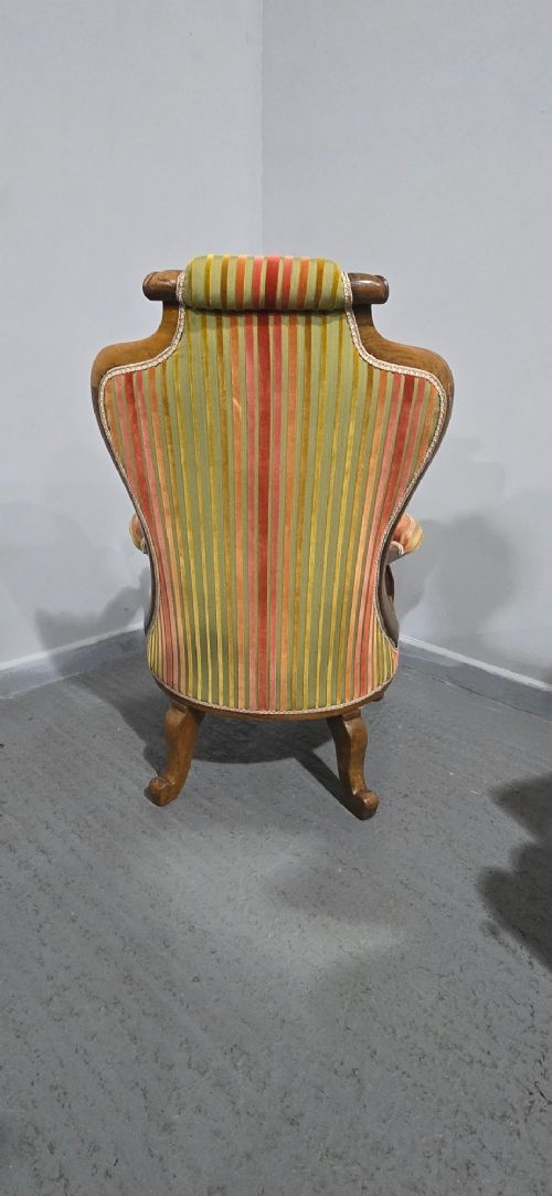 A Regency rosewood armchair featuring a button-tufted backrest, scrolled arms, carved legs, and striped green and red upholstery. View X
