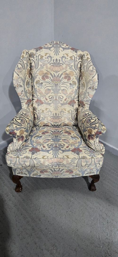 A high-backed wingback armchair upholstered in a botanical pattern with dark carved cabriole legs and ball-and-claw feet. View IV