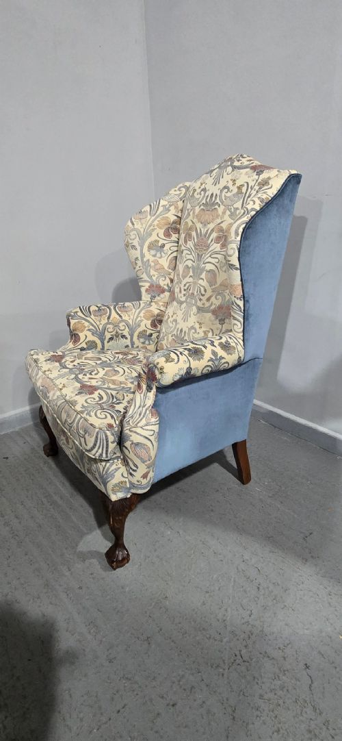 A high-backed wingback armchair upholstered in a botanical pattern with dark carved cabriole legs and ball-and-claw feet. View VII