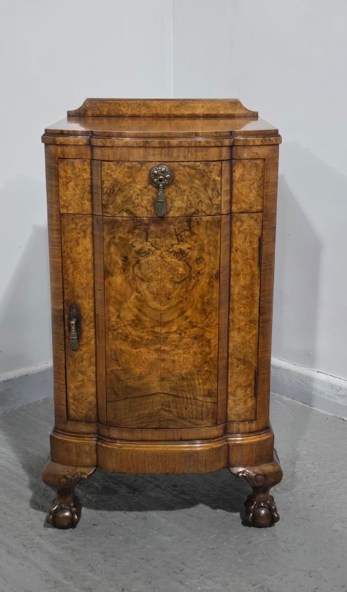fig 1. A small burr walnut side cabinet with a single upper drawer over a cupboard door, raised on carved cabriole legs with claw-and-ball feet.