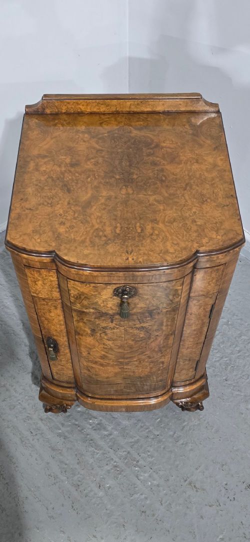 A small burr walnut side cabinet with a single upper drawer over a cupboard door, raised on carved cabriole legs with claw-and-ball feet. View VI