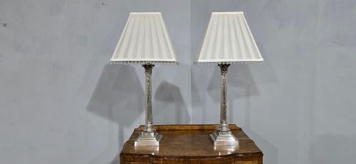 fig 1. A pair of silver-plated neoclassical column table lamps with square stepped plinths and white pleated shades featuring beaded lower trim.