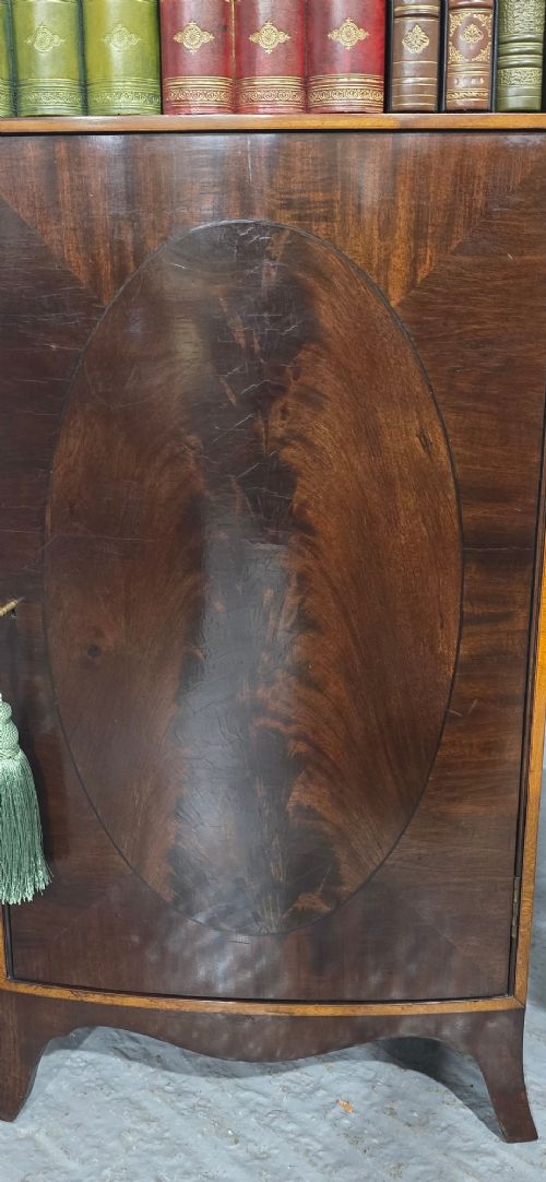 A pair of tall slim mahogany open bookcases featuring inlaid fan pediments, adjustable shelves, and curved lower cupboard doors. View VII