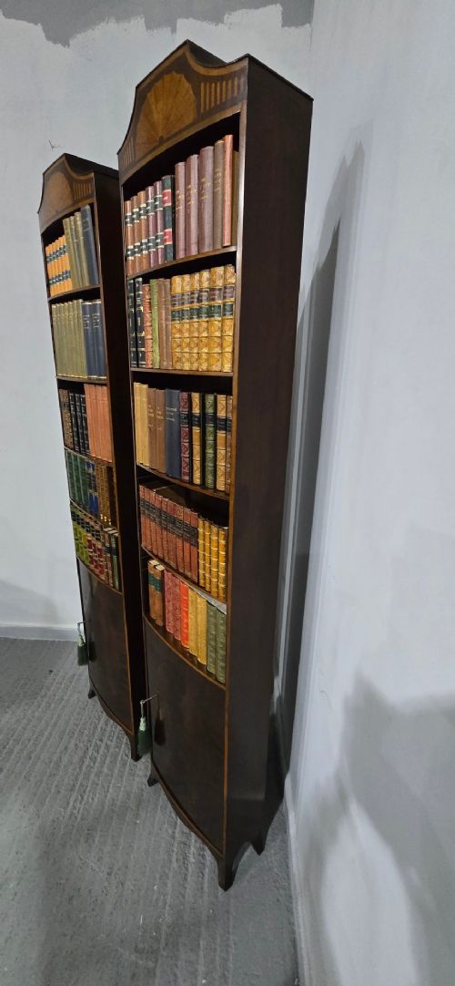 A pair of tall slim mahogany open bookcases featuring inlaid fan pediments, adjustable shelves, and curved lower cupboard doors. View VIII