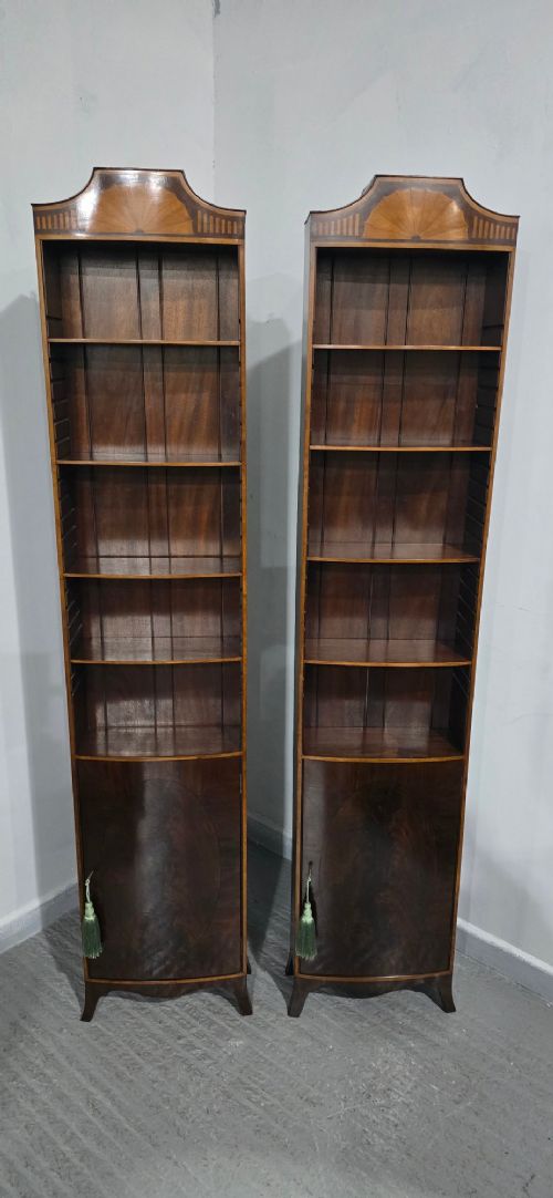 A pair of tall slim mahogany open bookcases featuring inlaid fan pediments, adjustable shelves, and curved lower cupboard doors. View XI