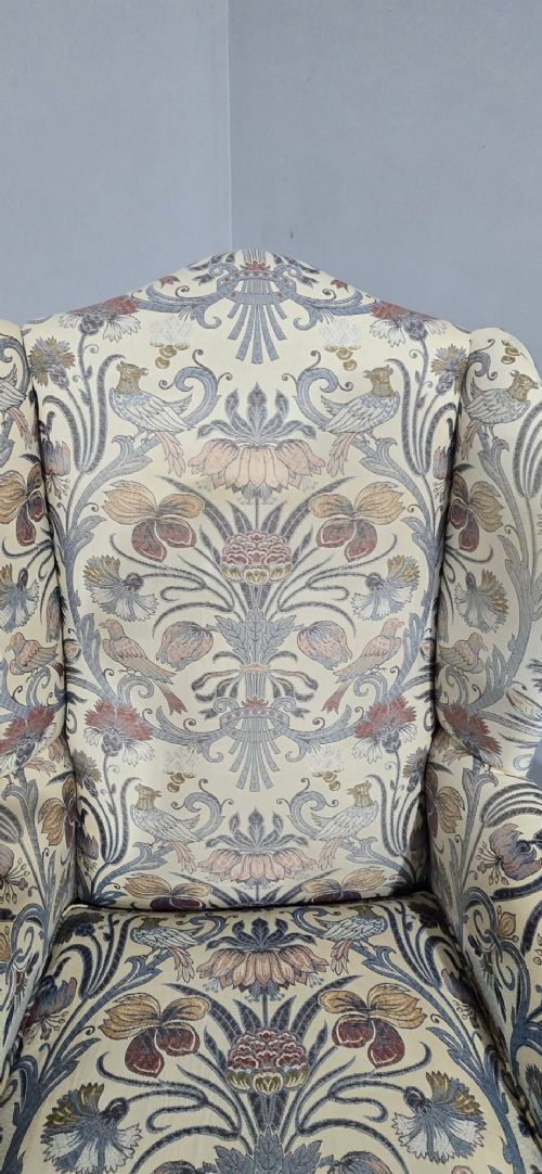A high-backed wing armchair upholstered in a botanical pattern fabric featuring dark mahogany cabriole front legs with carved ball and claw feet. View VIII