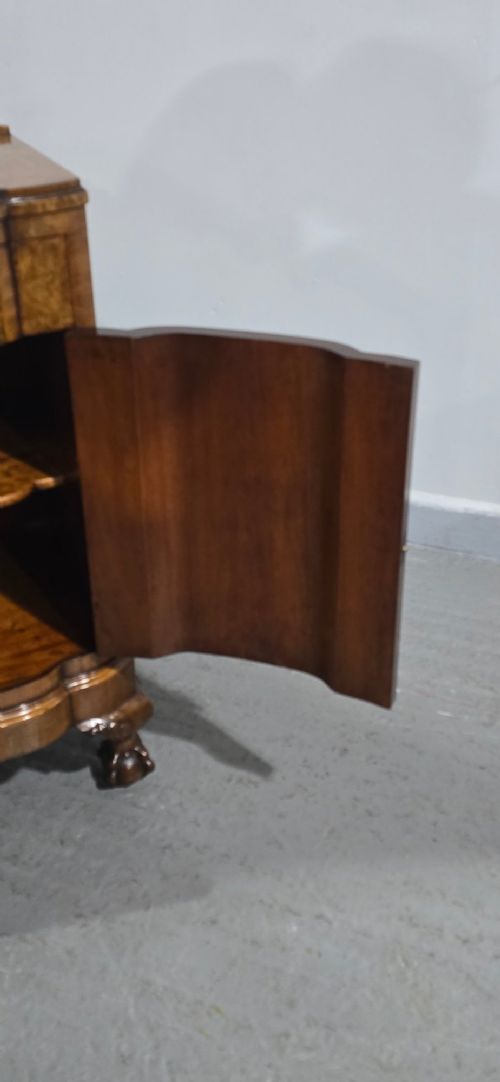 A burr walnut side cabinet with a bowed front, single drawer, cupboard door, and cabriole legs ending in carved claw and ball feet. View X
