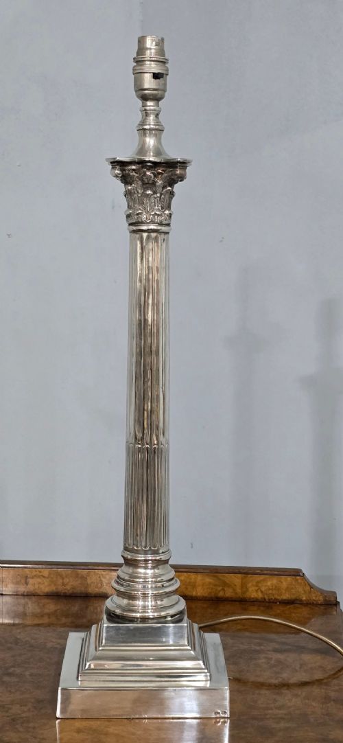 A pair of silver-plated table lamps styled as fluted Corinthian columns on stepped square bases, fitted with white pleated shades with beaded trim. View III