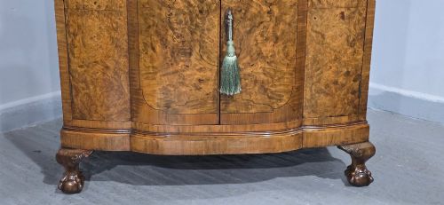 fig 1. A two-section burr walnut linen press featuring a breakfront profile, upper drawers with drop handles, lower cupboard doors, and carved cabriole legs.