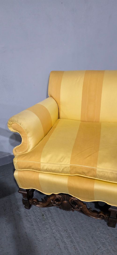 An upholstered sofa featuring yellow and gold vertical stripes with an intricately carved dark oak base decorated with shell motifs and scrolls. View VIII