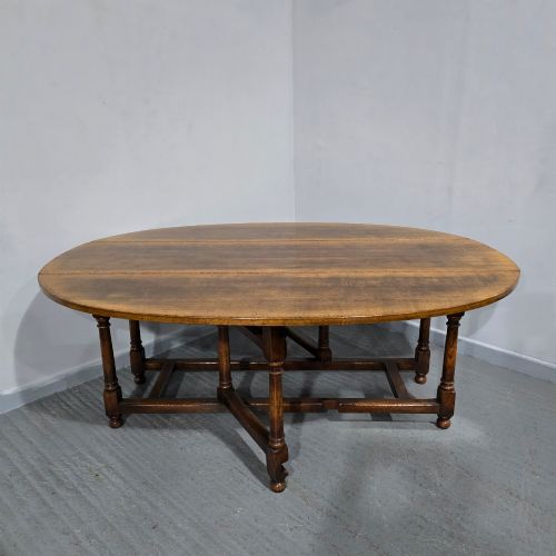 fig 1. A large oval solid oak wake table featuring drop-leaf sides, turned legs, and square stretchers.