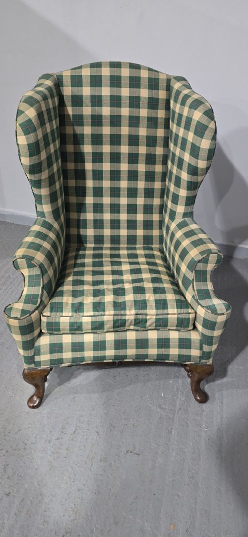 High-backed wingback armchair upholstered in green and cream check fabric with carved oak cabriole front legs. View X
