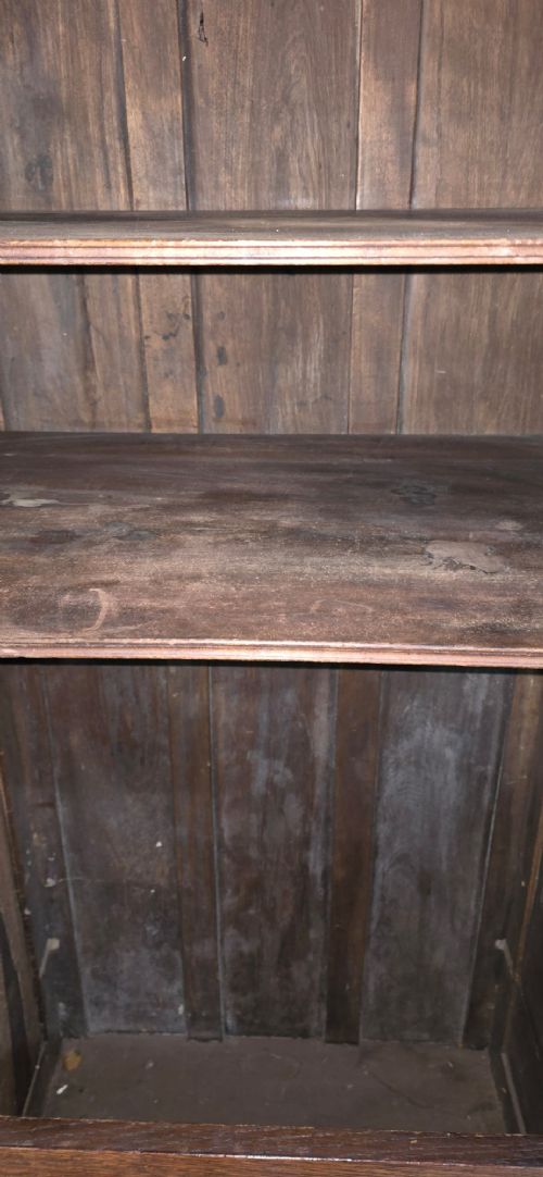 A tall, narrow antique dark oak food cupboard featuring panelled doors, hand-forged iron hinges, a metal ring drop handle, and a top moulded cornice. View XI