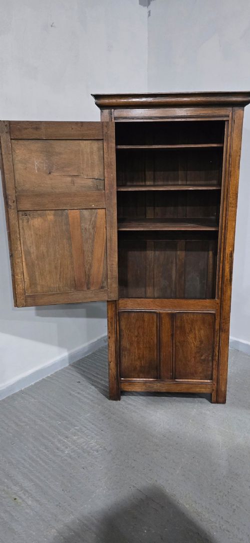 A tall, narrow antique dark oak food cupboard featuring panelled doors, hand-forged iron hinges, a metal ring drop handle, and a top moulded cornice. View XIII