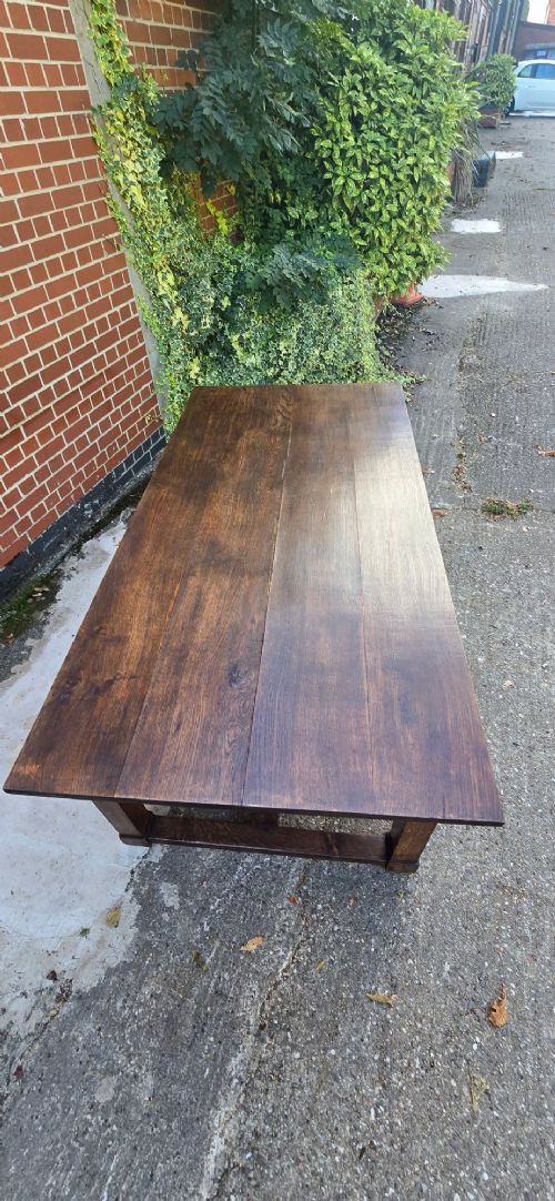 A solid warm brown French oak refectory dining table featuring a rectangular plank top, square legs, and an H-stretcher base. View VIII