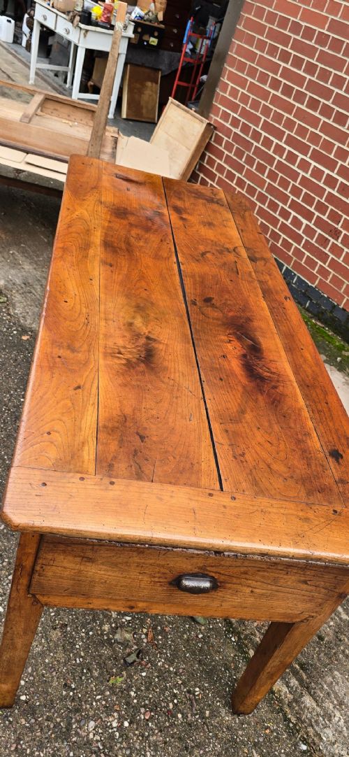 A rectangular French cherry wood refectory dining table featuring a three-plank top, side frieze drawer with metal handle, and square tapered legs. View IV